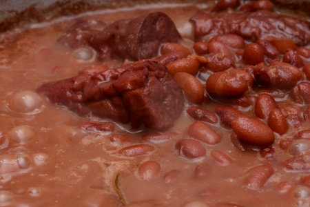 Brown brazilian beans being cooked showing details of the grains and sausages to tasteの写真素材