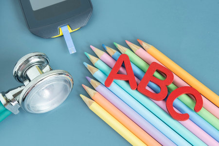 Back to school concept for kids with diabetes represented by colored pencils and glucometerの写真素材