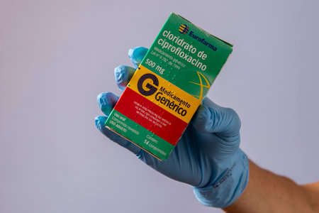 Rio, Brazil - January 27, 2023, hand with protective rubber glove holding medicine box, cipofloxacin hydrochlorideのeditorial素材