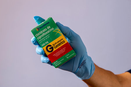 Rio, Brazil - January 27, 2023, hand with protective rubber glove holding medicine box of cipofloxacin hydrochlorideのeditorial素材