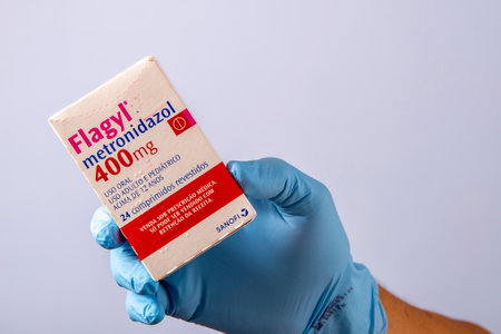 Rio, Brazil - January 27, 2023, hand with protective rubber glove holding medicine box, metronidazoleのeditorial素材