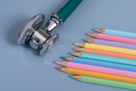 stethoscope and color pencils on blue background with copy spaceの写真素材