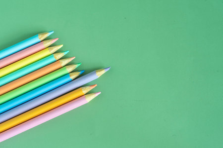 Pastel colored pencils, top view on green background, illustration concept, background and education and back to schoolの写真素材
