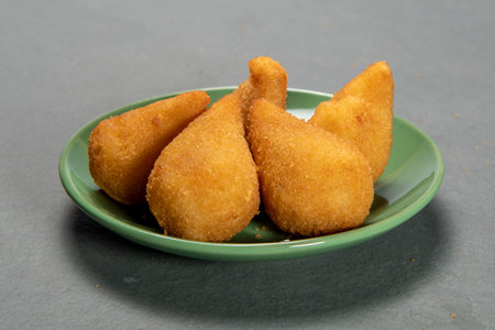 traditional fried coxinha in plate on slate background, popular brazilian snack served at partiesの写真素材