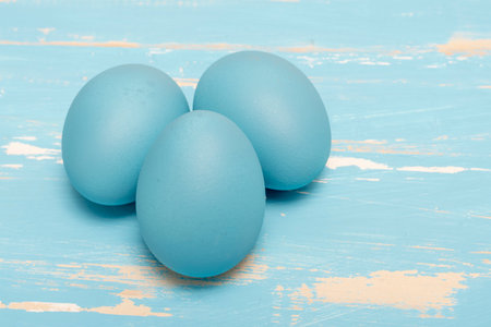 Eggs symbolizing the Easter holiday in blue color on a background of aged wood in the same colorの写真素材