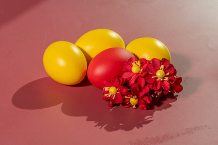 Colorful eggs symbolizing Easter on a colorful background and flowersの写真素材