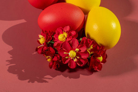 Colorful eggs symbolizing Easter on a colorful background and flowersの写真素材