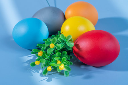 Colorful eggs symbolizing Easter on a colorful background and flowersの写真素材