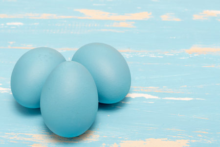 Eggs symbolizing the Easter holiday in blue color on a background of aged wood in the same colorの写真素材