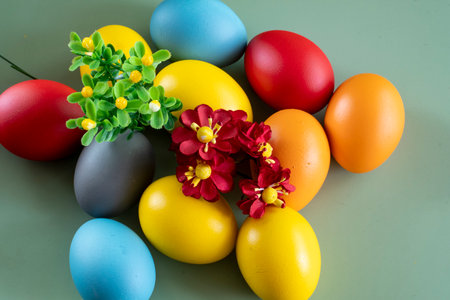 Colorful easter eggs and flowers on green background. happy easterの写真素材