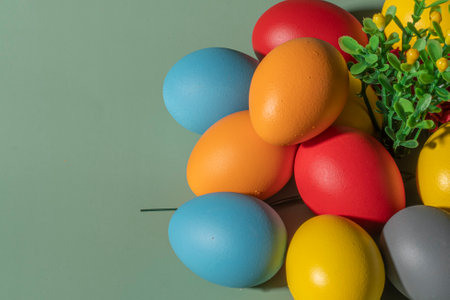 Colorful eggs symbolizing Easter on a colorful background and flowersの写真素材