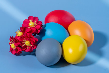 Colorful easter eggs and flowers on blue background. Happy Easter.の写真素材
