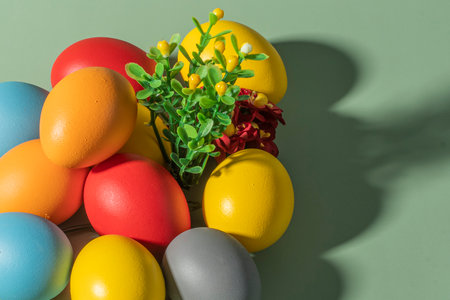Colorful eggs symbolizing Easter on a colorful background and flowersの写真素材