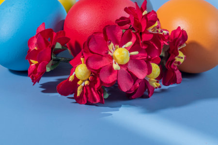 Colorful eggs symbolizing Easter on a colorful background and flowersの写真素材