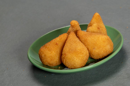 Fried chicken nuggets in a green plate on a gray backgroundの写真素材