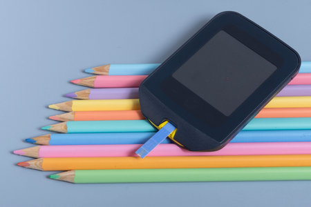 Colorful pencils and a digital tablet on a blue background.の写真素材