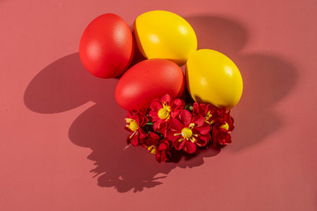 Easter eggs with red and yellow flowers on a red background.の写真素材