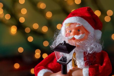 Santa Claus doll with lantern on bokeh background. Christmas concept.の写真素材