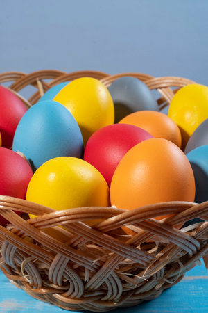easter basket with straw and colored eggs to symbolize a religious momentの写真素材