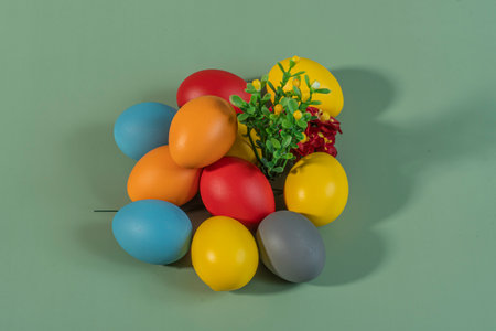 Colorful eggs symbolizing Easter on a colorful background and flowersの写真素材