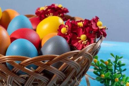 easter basket with straw and colored eggs to symbolize a religious momentの写真素材