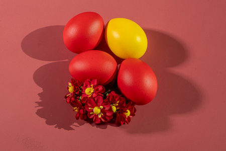 Colorful eggs symbolizing Easter on a colorful background and flowersの写真素材