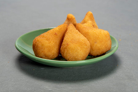 traditional fried coxinha in plate on slate background, popular brazilian snack served at partiesの写真素材