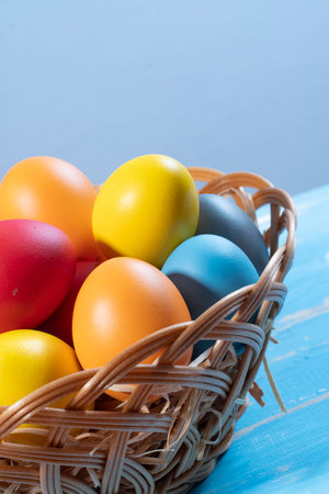 easter basket with straw and colored eggs to symbolize a religious momentの写真素材