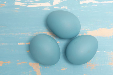 Eggs symbolizing the Easter holiday in blue color on a background of aged wood in the same colorの写真素材