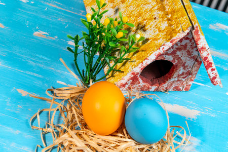 colorful eggs symbolizing easter with a toy house and flowers like a gardenの写真素材