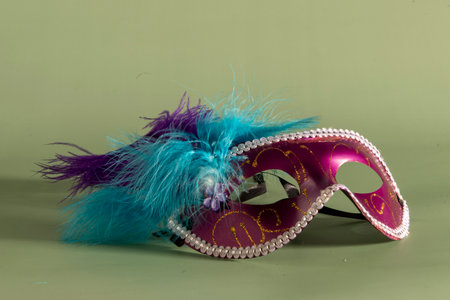 Carnival mask with feathers on a green background, closeupの写真素材