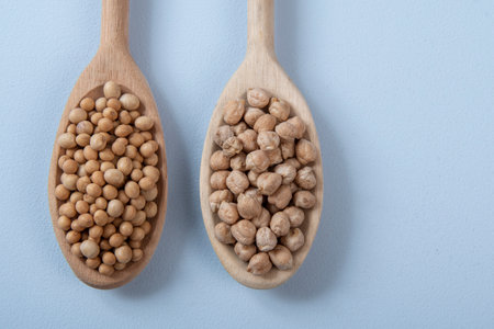 wooden spoon with chickpeas and soy in blue backgroundの写真素材