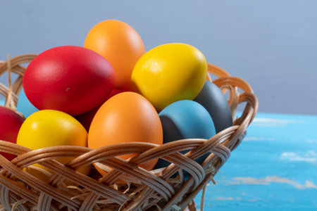 easter basket with straw and colored eggs to symbolize a religious momentの写真素材