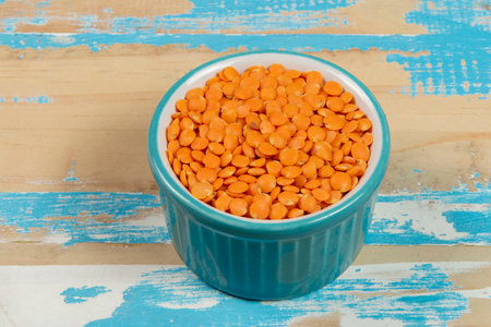 bowl with red lentils on rustic blue wooden table, up viewの写真素材