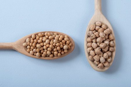 wooden spoon with chickpeas and soy in blue backgroundの写真素材
