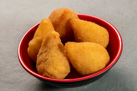traditional fried coxinha in plate on slate background, popular brazilian snack served at partiesの写真素材