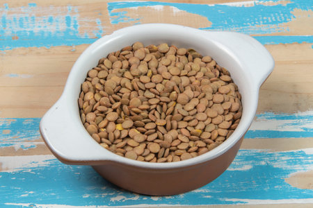 bowl with lentils on blue rustic wooden table, up viewの写真素材