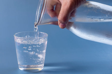 Unfilled glass of water on blue backgroundの写真素材