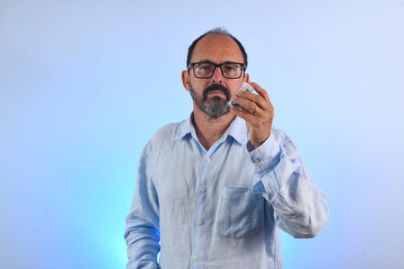 sixty year old man holding a medicine bottleの写真素材