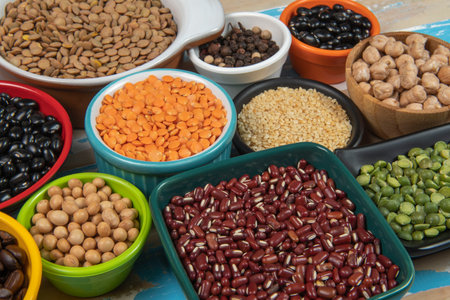 variety of beans and lentils in colorful bowls on wood backgroundの写真素材