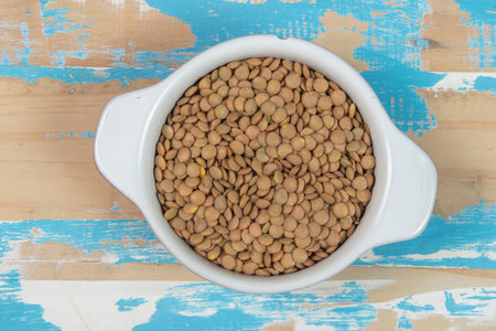 lentils in a bowl on a wooden background, top viewの写真素材