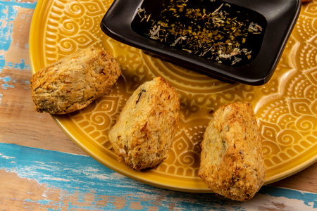 Fried codfish fritters in portions, with a bowl of olive oilの写真素材