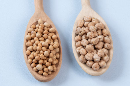 wooden spoon with chickpeas and soy in blue backgroundの写真素材