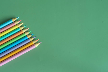 Pastel colored pencils, top view on green background, illustration concept, background and education and back to schoolの写真素材