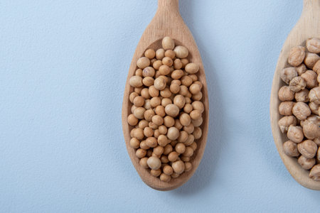 wooden spoon with chickpeas and soy in blue backgroundの写真素材