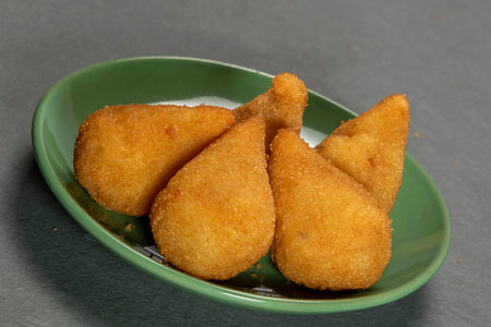 traditional fried coxinha in plate on slate background, popular brazilian snack served at partiesの写真素材