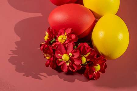 Colorful eggs symbolizing Easter on a colorful background and flowersの写真素材