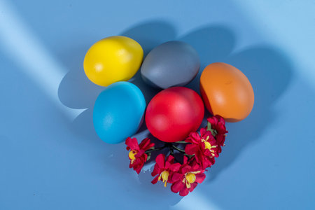 Colorful eggs symbolizing Easter on a colorful background and flowersの写真素材