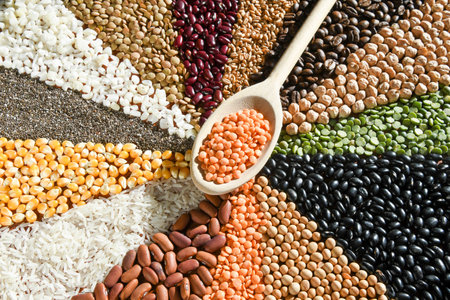 Wooden spoon with raw red lentils on various seedsの写真素材