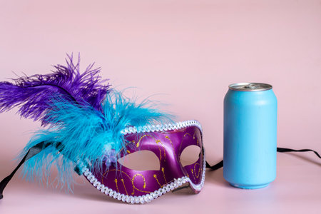 Purple carnival mask, can and blue feather on pink backgroundの写真素材